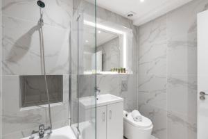 a bathroom with a shower and a toilet and a sink at Bright and spacious Apartment - Excellent Location in London