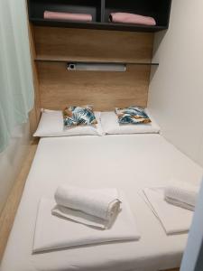 2 Handtücher auf einem Bett in einem Zimmer in der Unterkunft CHARTA mobile home Maya in Pirovac