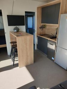 uma cozinha com uma mesa e um frigorífico em CHARTA mobile home Maya em Pirovac
