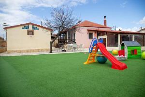 um quintal com um parque infantil com um escorrega em Entertainment house Καστορια em Castória