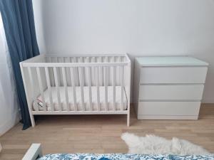 a nursery with a white crib and a table at Appartement chaleureux à 10 minutes de la Défense in Nanterre