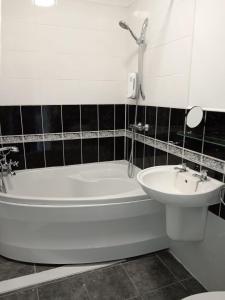 a bathroom with a white tub and a sink at Martello Hotel in Hull