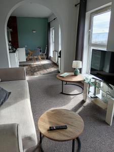 a living room with a couch and tables and a tv at Martello Hotel in Hull