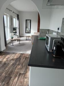 a living room with a counter top with a microwave at Martello Hotel in Hull