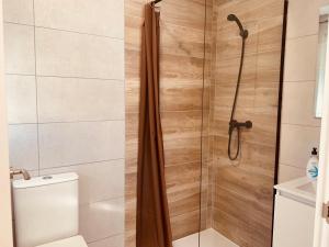 y baño con ducha, aseo y lavamanos. en LURGORRI APARTAMENTOS by Gernihost, en Guernica y Luno