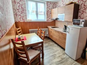 a small kitchen with a table and a refrigerator at Penzion Pod Zámkem in Vizovice