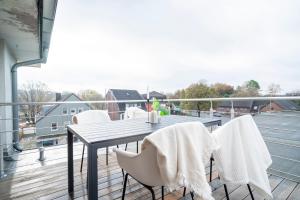 a balcony with a table and chairs on a roof at Juno - #1 Terrassen-Apartment, Netflix, WLAN in Bottrop