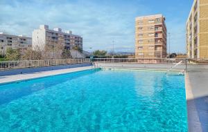 duży niebieski basen z dwoma wysokimi budynkami w obiekcie 2 Bedroom Beautiful Apartment In La Pobla De Farnals w mieście Las Canteras