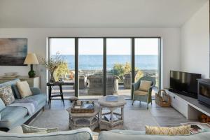 a living room with a view of the ocean at Stunning architect designed beachfront property in Selsey