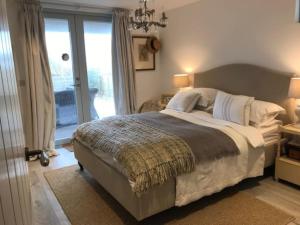 a bedroom with a large bed and a window at Stunning architect designed beachfront property in Selsey
