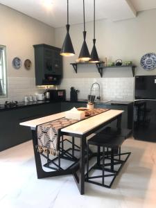 a kitchen with a table and some black cabinets at Rumah Kenyeri in Denpasar