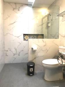 a white bathroom with a toilet and a mirror at Rumah Kenyeri in Denpasar