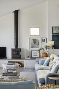 a living room with two couches and a fireplace at Stunning architect designed beachfront property in Selsey