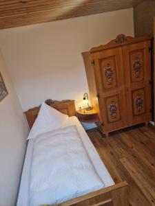 een slaapkamer met een bed en een houten dressoir bij Gasthof Hosbein in Heiligenberg