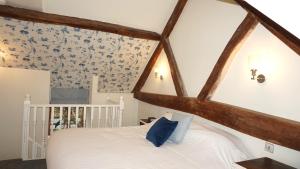 una camera da letto con letto bianco e carta da parati floreale blu di Wheat Cottage - 5* Cyfie Farm with private covered hot tub a Llanfyllin Altre 14 foto