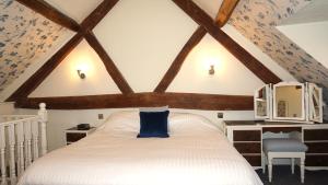 una camera con letto bianco e cuscino blu di Wheat Cottage - 5* Cyfie Farm with private covered hot tub a Llanfyllin