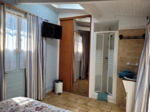 1 dormitorio con 1 cama y TV en la pared en Chambres d’Hôtes Chez Claire en Beuvron-en-Auge