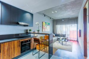 a kitchen with black cabinets and a living room at Résidence Galilée - Gauthier in Casablanca