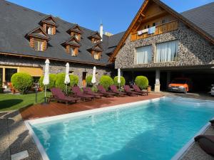 a house with a swimming pool in front of a house at Hotel Koliba in Senec