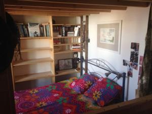 uma cama num quarto com uma estante de livros em Entire house with garden special for Olympique game 2024 em Ivry-sur-Seine