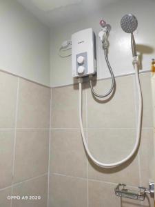 La salle de bains est pourvue d'une douche avec un pommeau de douche. dans l'établissement Persimmon Studio Single Unit, à Cebu