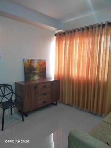 a living room with a wooden dresser and a curtain at Persimmon Studio Single Unit in Cebu City