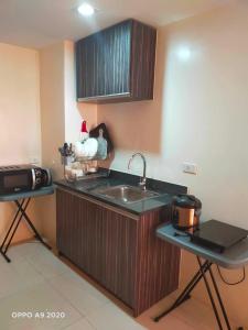 eine Küche mit einer Spüle und einer Mikrowelle in der Unterkunft Persimmon Studio Single Unit in Cebu City