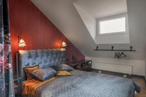 um quarto com uma cama e uma parede vermelha em Cozy Penthouse em Vilnius