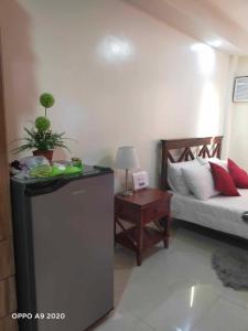 a room with a bed and a table with a plant at Persimmon Studio Single Unit in Cebu City
