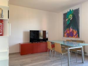 une salle à manger avec une table en verre et une télévision dans l'établissement Appartamento Du Lac, à Baveno
