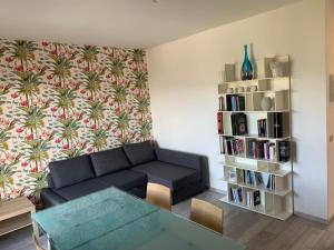 - un salon avec un canapé et une étagère à livres dans l'établissement Appartamento Du Lac, à Baveno