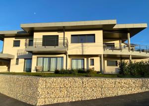 a large apartment building with a stone wall in front of it at CHAMBRES D'HOTES Chez Nicole et Christian in Villaz