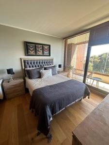 a bedroom with a large bed and a large window at Departamento Nuevo en Condominio La Puntilla Villarrica in Pucón +20 photos
