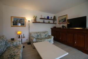 a living room with a couch and a flat screen tv at Casa Melina 2 in Tremezzo