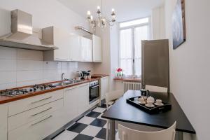a kitchen with a black and white checkered floor at Teatro Ariston & Piazza Colombo Elegant Apartment in Sanremo