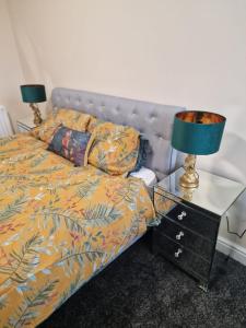 ein Schlafzimmer mit einem Bett und einem Tisch mit Lampen in der Unterkunft Levy Nook 3 in Darlington