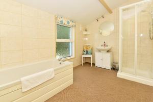 a bathroom with a tub and a sink at Pembroke Villa in Shanklin