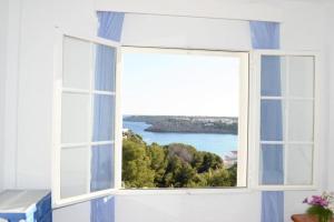 una ventana abierta con vistas al océano en Apartamento Castellsol 105., en Arenal d'en Castell