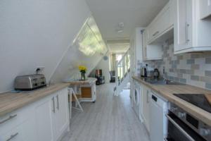 een keuken met witte kasten en een aanrechtblad bij Chalet Thirtyone in Deal