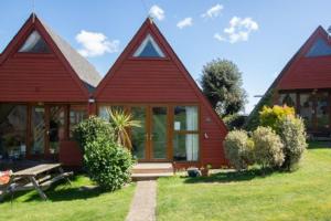 una casa roja con un banco delante en Chalet Thirtyone, en Deal