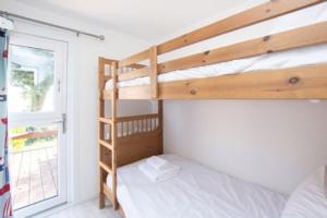 een slaapkamer met twee stapelbedden en een raam bij Chalet Thirtyone in Deal