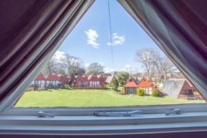 een raam met uitzicht op een tuin met huizen bij Chalet Thirtyone in Deal