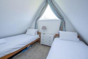 two twin beds in a room with a window at Chalet Thirtyone in Deal +21 photos