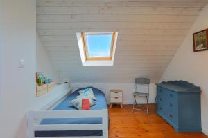 - une chambre pour enfants avec un lit bleu et une fenêtre dans l'établissement Maison du Sillon, à Pleubian