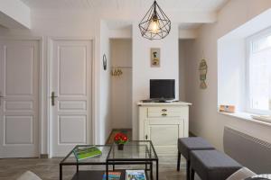 un soggiorno con tavolo e TV di Maison du Sillon a Pleubian