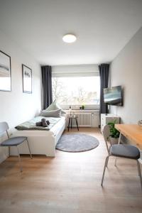 sala de estar con sofá blanco y mesa en Juno - #1 Terrassen-Apartment, Netflix, WLAN, en Bottrop