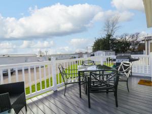 a patio with a table and chairs on a deck at Seasalt in West Mersea