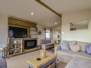 a living room with a couch and a tv at Seasalt in West Mersea