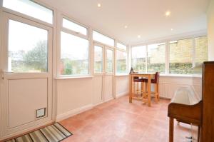 a room with windows and a table and a chair at St Georges Villa in Ryde