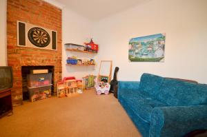 a living room with a blue couch and a fireplace at St Georges Villa in Ryde